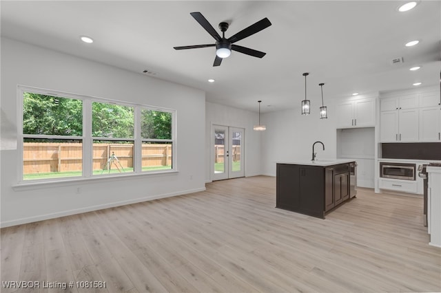 9009 Carson Way, Fort Smith, AR 72908 - kitchen with stainless steel microwave, recessed lighting, a sink, white cabinetry, and light wood-type flooring