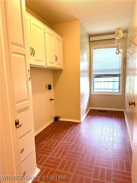 1800 N 45th Ter, Fort Smith, AR 72904 - laundry room featuring cabinet space, baseboards, brick flooring, a textured ceiling, and electric dryer hookup