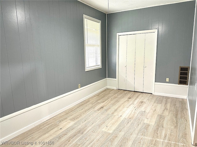 1800 N 45th Ter, Fort Smith, AR 72904 - unfurnished bedroom with wood finished floors, wooden walls, and a closet