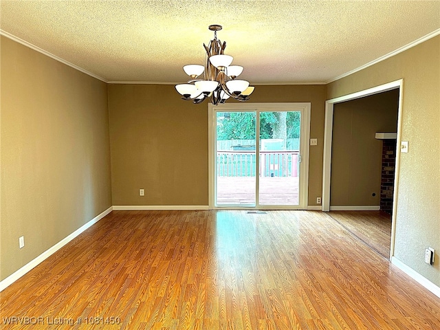 1800 N 45th Ter, Fort Smith, AR 72904 - empty room featuring a textured ceiling, a chandelier, crown molding, wood finished floors, and baseboards
