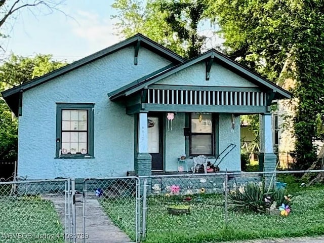 612 N 8th St, Fort Smith, AR 72901 - bungalow-style house featuring covered porch, a fenced front yard, stucco siding, and a gate