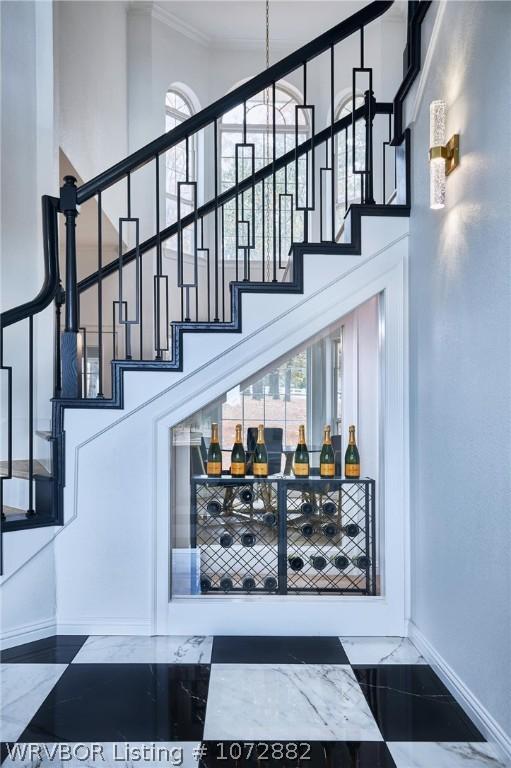 bar featuring a towering ceiling and ornamental molding