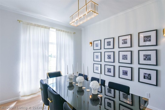 dining room featuring crown molding, light hardwood / wood-style flooring, and an inviting chandelier