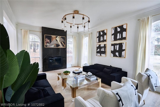 living room featuring a healthy amount of sunlight, crown molding, and a fireplace