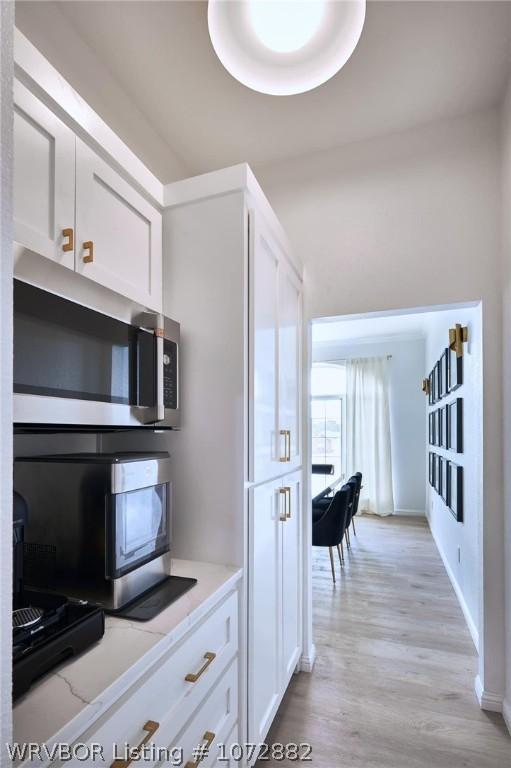 kitchen featuring light wood-type flooring and white cabinetry