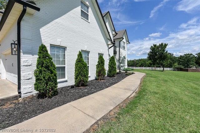 view of side of property featuring a garage and a yard