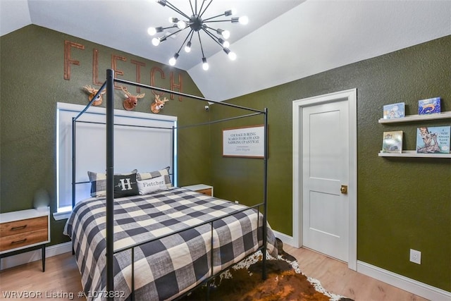 bedroom with hardwood / wood-style floors, a chandelier, and lofted ceiling