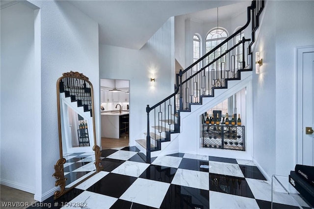 foyer entrance featuring sink and a high ceiling