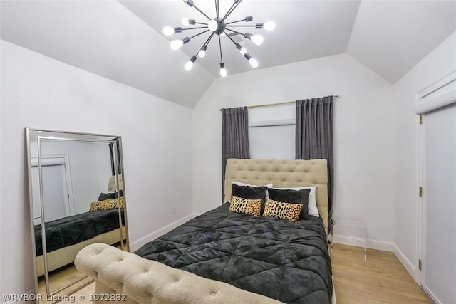 bedroom featuring a chandelier, vaulted ceiling, and light hardwood / wood-style flooring