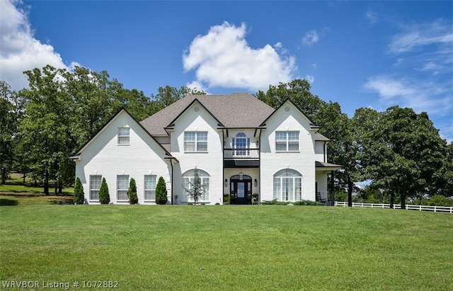 view of front facade featuring a balcony and a front lawn