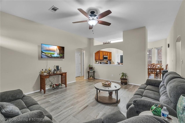 living room with ceiling fan and light wood-type flooring