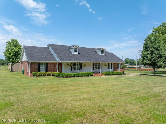 1205 S Division St, Lavaca, AR 72941 - view of front facade featuring brick siding, covered porch, a front yard, and roof with shingles