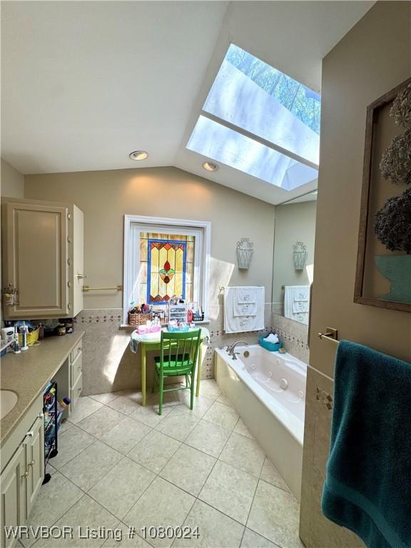 9704 Apple Gate Dr, Fort Smith, AR 72903 - full bathroom with vaulted ceiling with skylight, a garden tub, vanity, tile patterned floors, and plenty of natural light