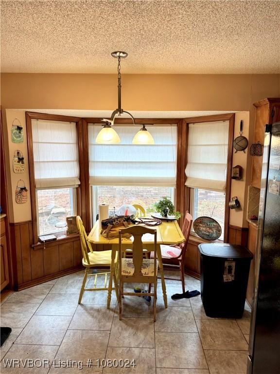 9704 Apple Gate Dr, Fort Smith, AR 72903 - dining area with light tile patterned floors, wainscoting, and a textured ceiling