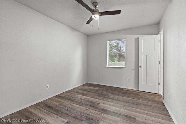 unfurnished room with a ceiling fan, wood finished floors, and baseboards