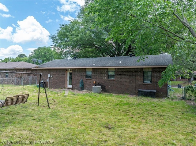 rear view of property featuring brick siding and a shingled roof