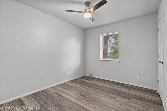 unfurnished room featuring wood finished floors, ceiling fan, and baseboards