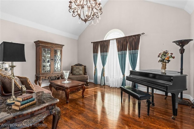 living area with high vaulted ceiling, baseboards, an inviting chandelier, and wood finished floors