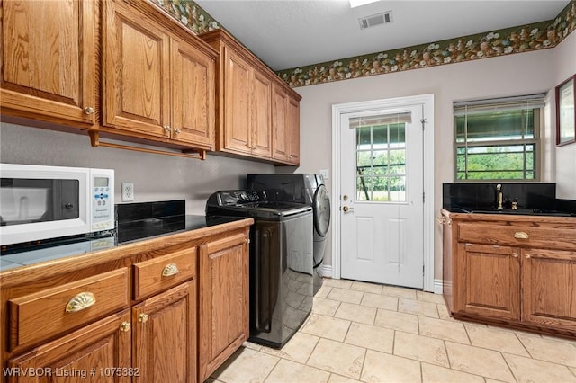 laundry area featuring cabinet space, visible vents, and separate washer and dryer