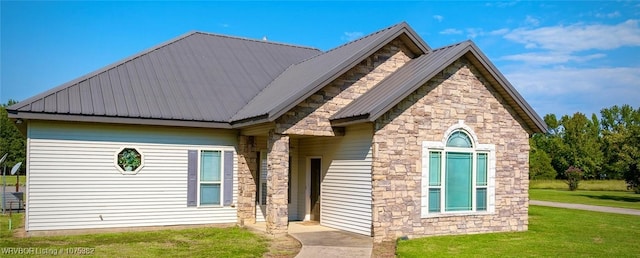 view of front facade featuring metal roof and a front lawn