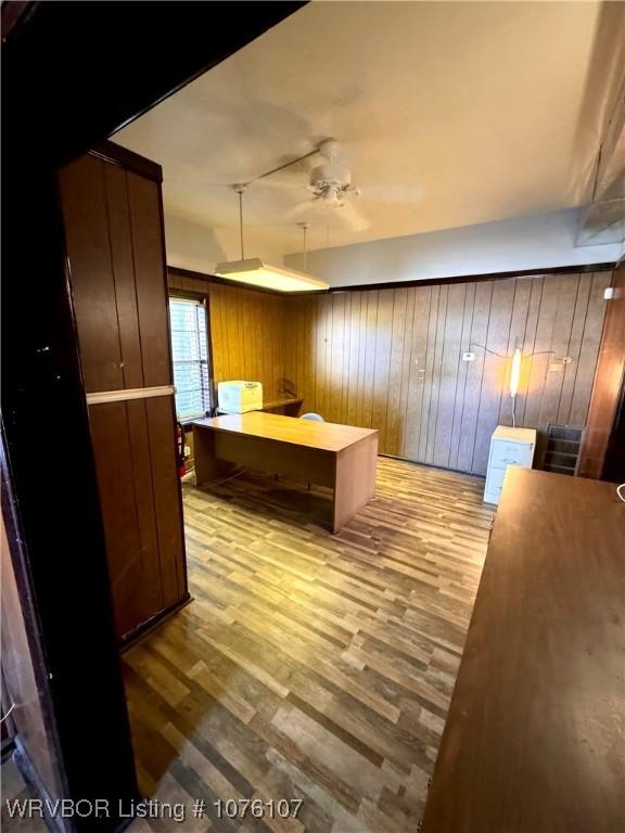 kitchen with kitchen peninsula, light hardwood / wood-style floors, and wooden walls