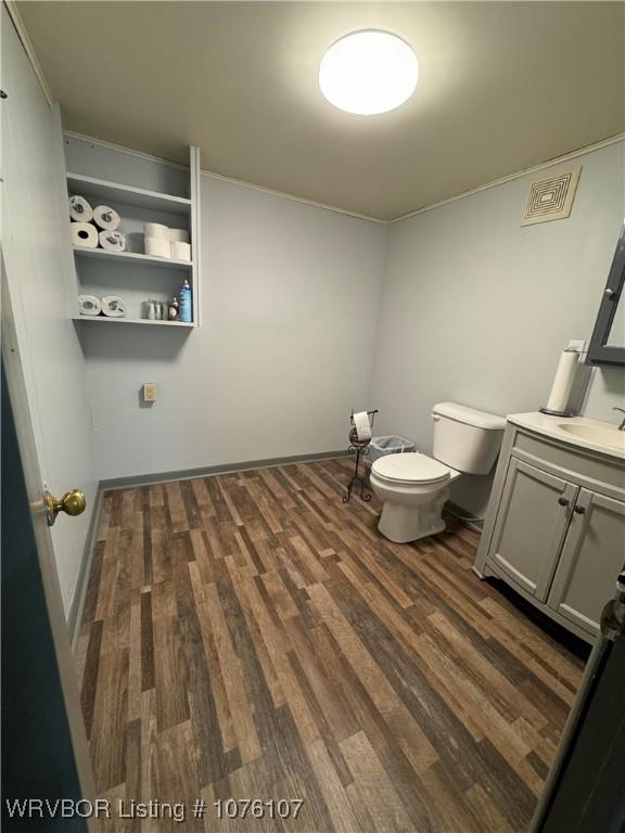 bathroom with hardwood / wood-style floors, vanity, and toilet