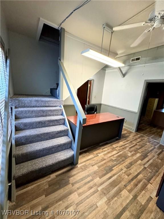 stairway featuring hardwood / wood-style floors and ceiling fan