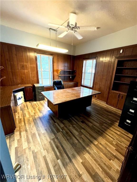 interior space featuring wooden walls, a healthy amount of sunlight, and a textured ceiling