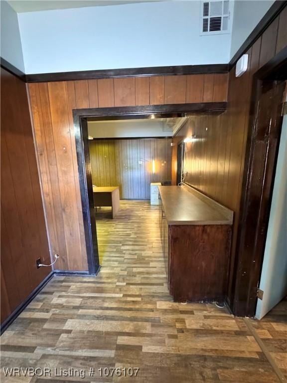 corridor featuring hardwood / wood-style flooring and wood walls