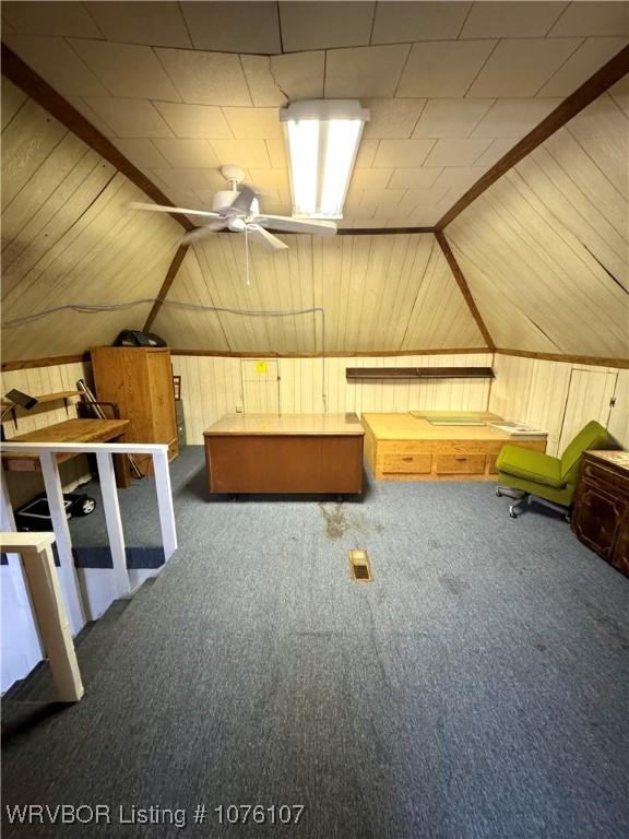 additional living space with dark carpet, ceiling fan, and lofted ceiling