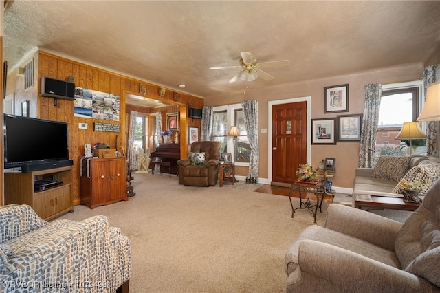 living area featuring light carpet, visible vents, a healthy amount of sunlight, and ceiling fan