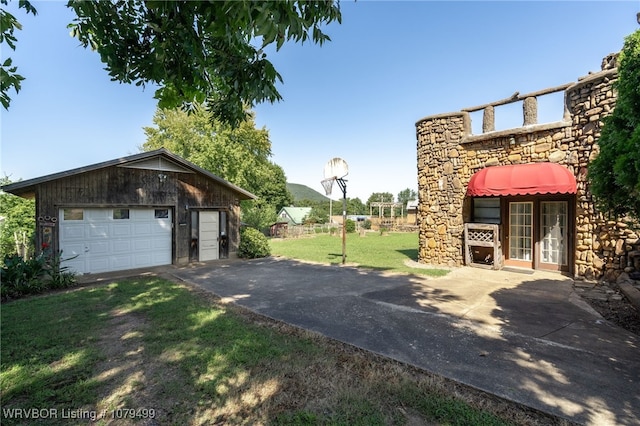 exterior space with aphalt driveway, an outbuilding, and a garage