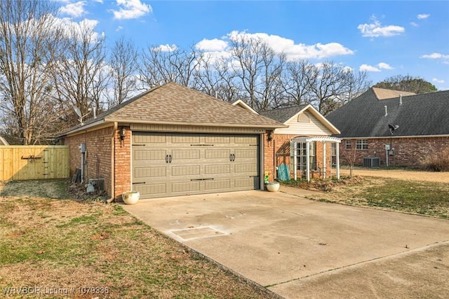 view of front of home with an outbuilding, brick siding, central air condition unit, a shingled roof, and fence