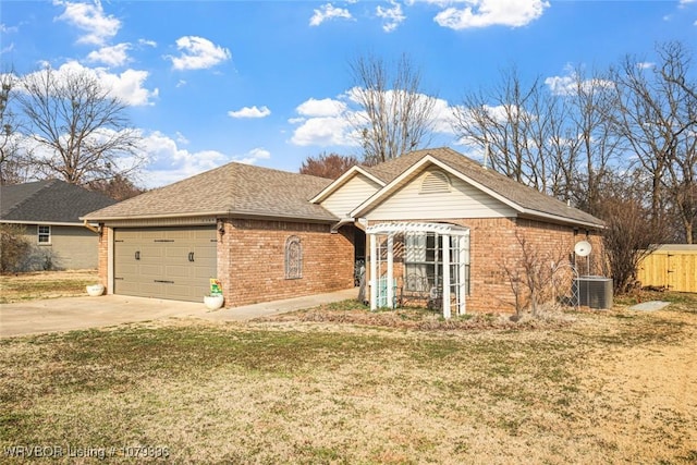 ranch-style house featuring a garage, brick siding, concrete driveway, cooling unit, and a front yard