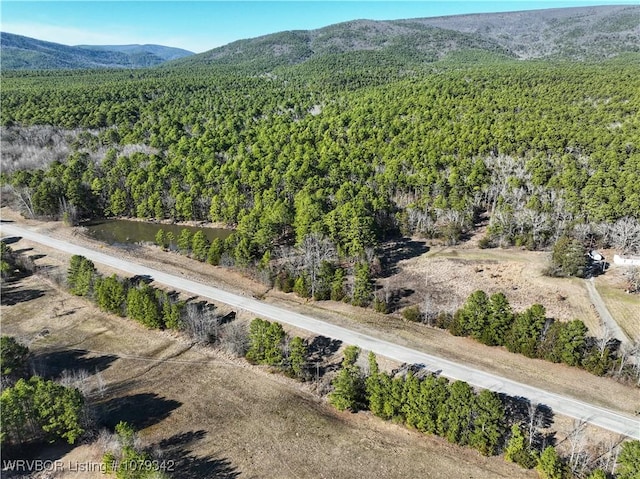 drone / aerial view featuring a mountain view and a view of trees