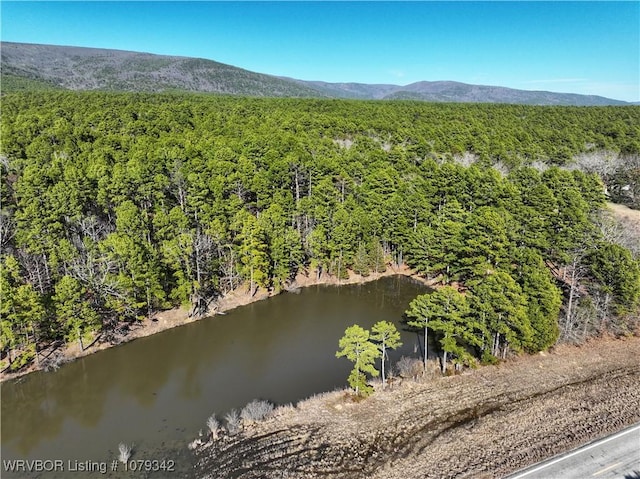 aerial view featuring a forest view and a water and mountain view