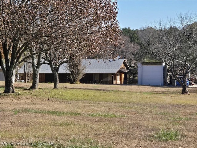 view of front of property with a garage, an outbuilding, and a front yard