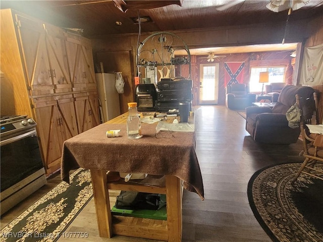 dining room featuring ceiling fan, wood walls, dark hardwood / wood-style flooring, and wood ceiling