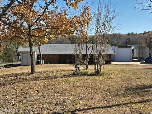 view of front of home with a front lawn, central AC unit, a garage, and a carport