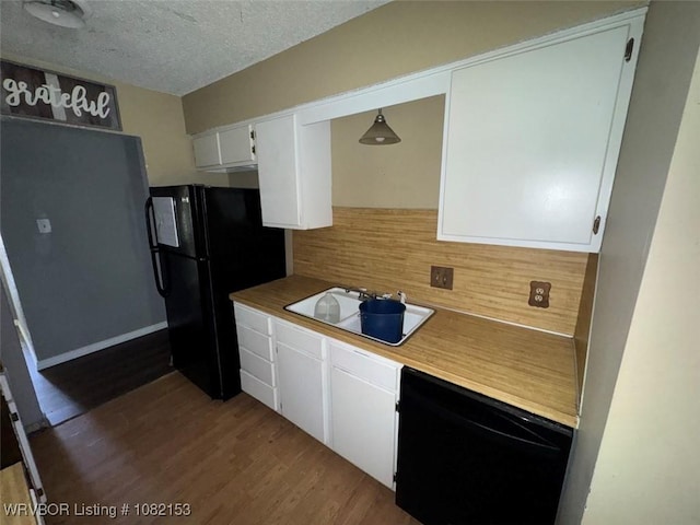 412 7th St, Barling, AR 72923 - kitchen with black appliances, backsplash, wood finished floors, white cabinetry, and a textured ceiling