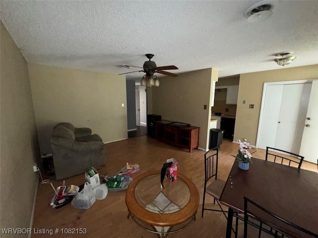 412 7th St, Barling, AR 72923 - living area with wood finished floors, a ceiling fan, and a textured ceiling