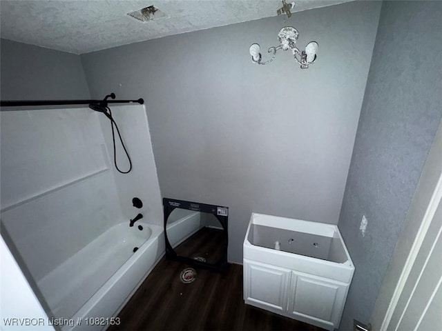 412 7th St, Barling, AR 72923 - full bath featuring wood finished floors, a textured ceiling, a chandelier, and shower / washtub combination