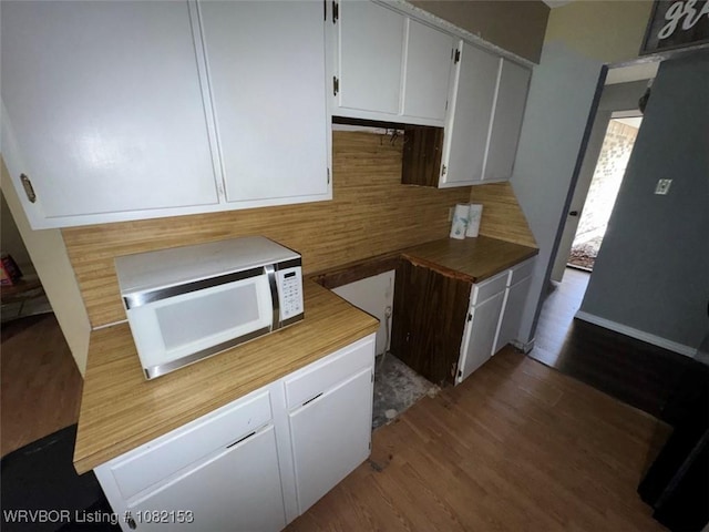 412 7th St, Barling, AR 72923 - kitchen with white microwave, decorative backsplash, dark wood-type flooring, and white cabinetry