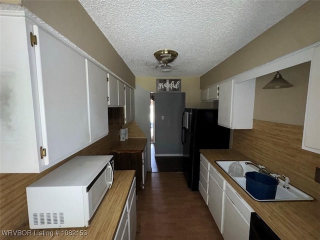 412 7th St, Barling, AR 72923 - kitchen featuring white microwave, backsplash, a textured ceiling, butcher block countertops, and white cabinets