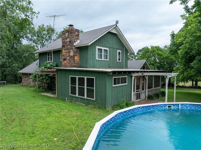 2650 Spielerville Rd, Paris, AR 72855 - rear view of house with roof with shingles, board and batten siding, an outdoor pool, a pergola, and a lawn