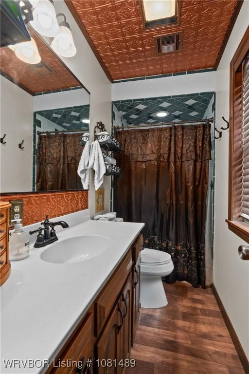 2650 Spielerville Rd, Paris, AR 72855 - bathroom with vanity, wood finished floors, toilet, a shower with shower curtain, and an ornate ceiling