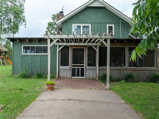 2650 Spielerville Rd, Paris, AR 72855 - view of front facade featuring a front yard, a chimney, a sunroom, and board and batten siding