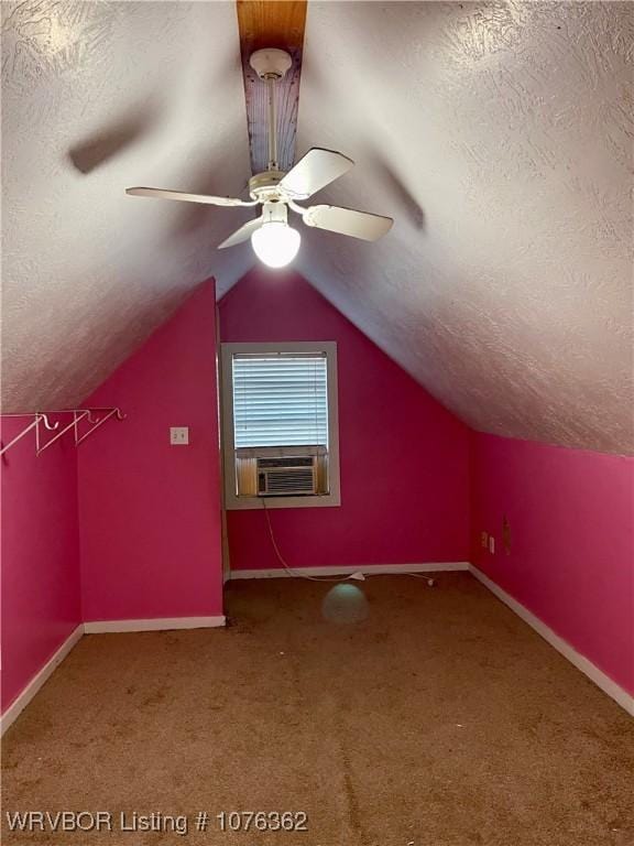 additional living space with carpet flooring, cooling unit, lofted ceiling, and a textured ceiling