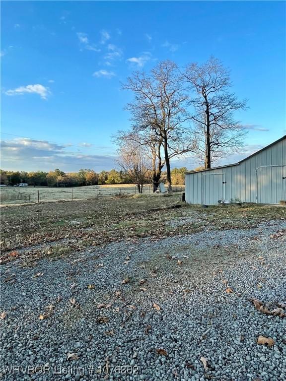 view of yard featuring a rural view and an outbuilding