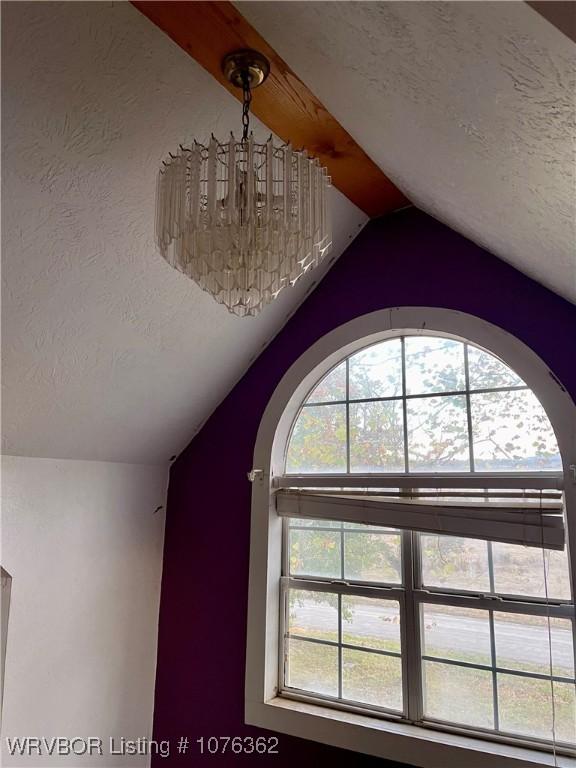 interior details with a textured ceiling and a notable chandelier